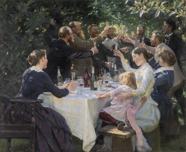 Group of seven men, three women, and one girl gathered around a table in a garden toasting with glasses of champagne.